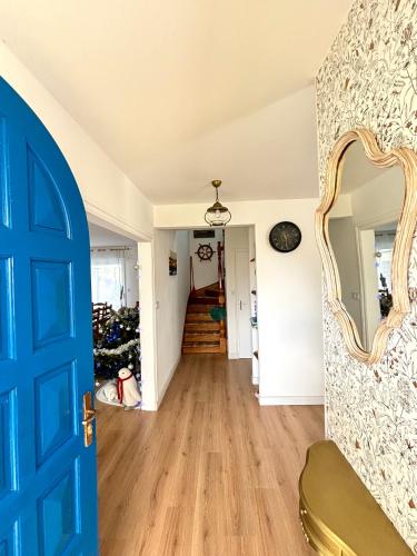 un couloir avec une porte bleue et un arbre de Noël dans l'établissement Maison idéale avec enfant, à Porspoder