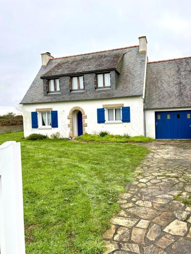 une maison blanche avec des portes bleues et une cour dans l'établissement Maison idéale avec enfant, à Porspoder
