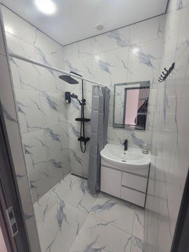 a white bathroom with a sink and a mirror at Tsaghkadzor Inn Guest House in Tsaghkadzor
