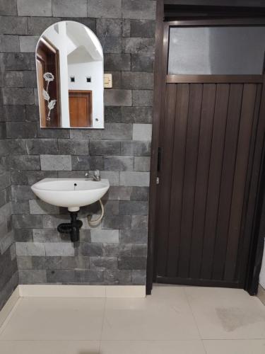 a bathroom with a sink and a mirror at Kadipiro Homestay in Ngabean