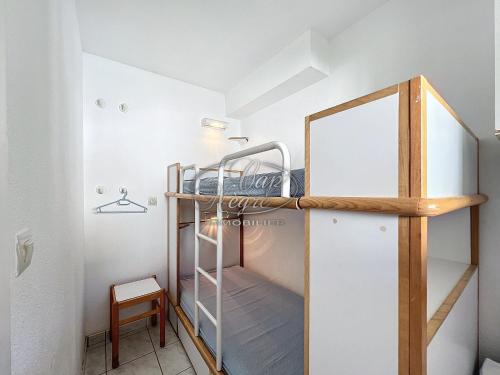 Cette petite chambre comprend des lits superposés et un miroir. dans l'établissement Appartement pour 4 personnes à 50 m de la plage, au Lavandou