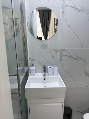 a white bathroom with a sink and a mirror at Luxury Studio in Victoria, 7 minutes walk to Victoria Station, Room 5 in London