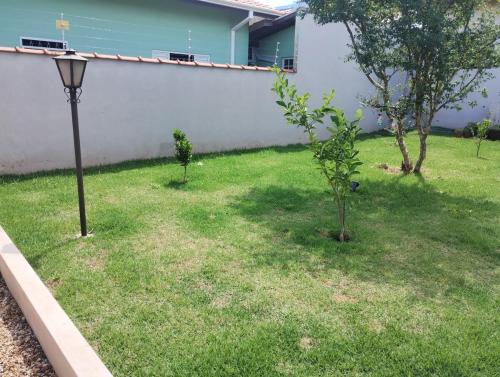 a yard with two trees and a street light at Casinha inteligente in Botucatu