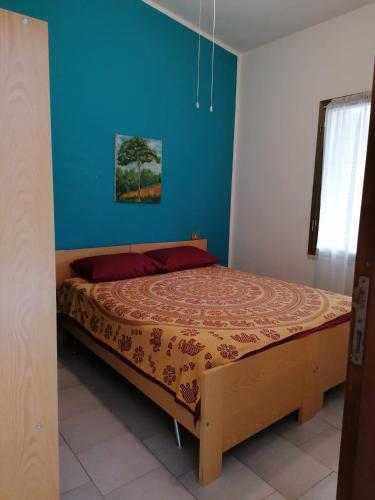 a bed in a bedroom with a blue wall at Stella Marina in Tertenìa