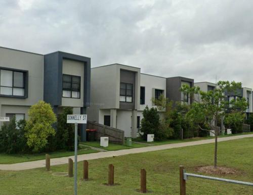 a street sign in front of a building at Modern Elegance Near Lakes Train Parks and Beaches in North Lakes