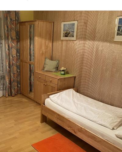 a bedroom with a bed and a cabinet and a table at Hotel-Restaurant-Vinothek Felix Sommer in Auersthal