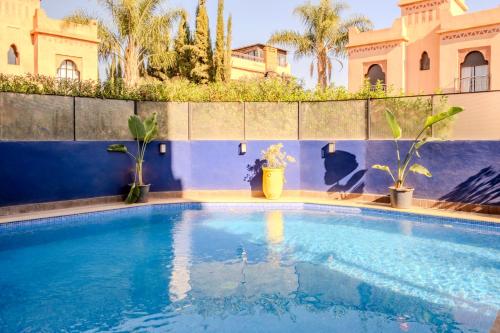a swimming pool in front of a house at Luxury Villa with Pool, Garden & Gated Security in Marrakech