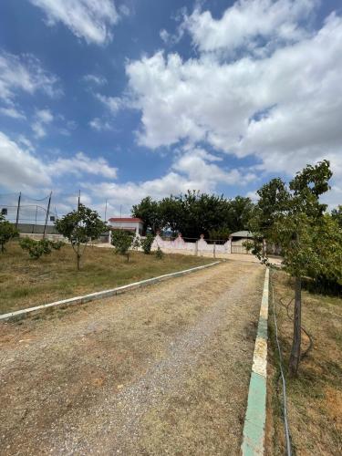 an empty road with a fence and trees on the side at Farmhouse in Kamouni in Dar Caïd Ahemd