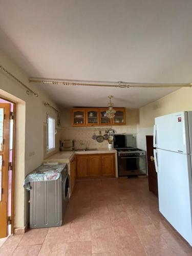 a kitchen with a white refrigerator and a dishwasher at Farmhouse in Kamouni in Dar Caïd Ahemd