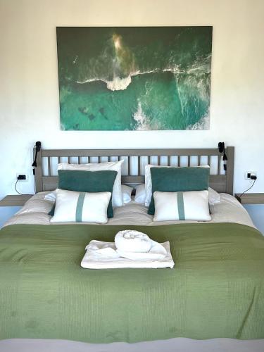 a bedroom with a large bed with a painting on the wall at Estudio ideal para descansar in Santa Cruz de Tenerife