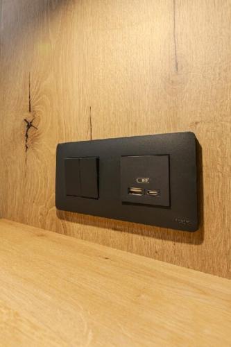 a black electrical outlet on a wooden wall at Hotel Tříška in Brandýs nad Labem