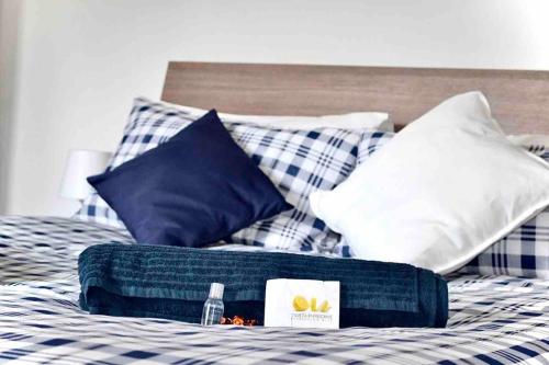 a bed with blue and white plaid pillows and a tray on it at Sea Trail in Avegno