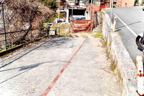 an empty street with a fence on the side of the road at Sea Trail in Avegno