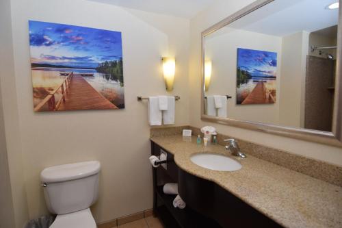 a bathroom with a sink and a toilet and a mirror at Cicero Grand - Syracuse North in Cicero