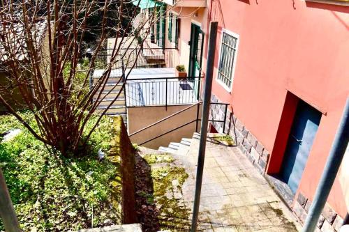 a pink building with a staircase leading to a door at Sea Trail in Avegno
