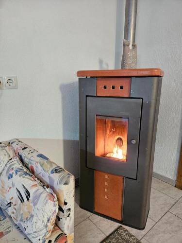 a oven with a fire in it next to a couch at apartment harmony in Sautens