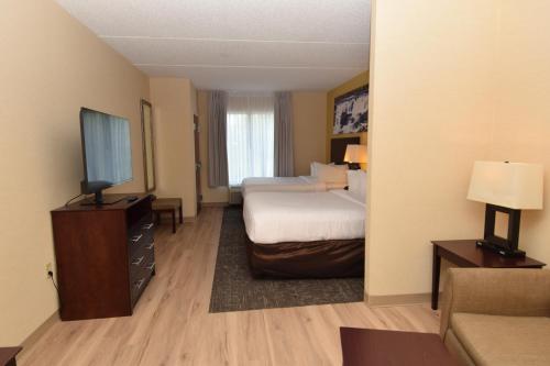 a hotel room with two beds and a flat screen tv at Cicero Grand - Syracuse North in Cicero