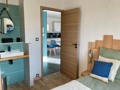 a bedroom with a bed and a sink and a mirror at App'ART GALERIE Vue mer in Sausset-les-Pins