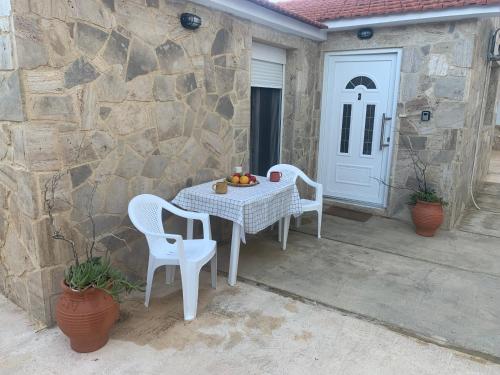 a table and chairs on a patio with a door at Lemon tree Gr in Xylokastron