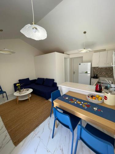 a kitchen and living room with a table and blue chairs at Lemon tree Gr in Xylokastron