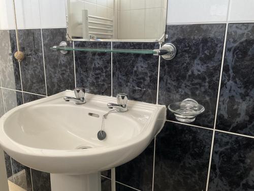 a white sink in a bathroom with a mirror at Traeth Rooms in Cardigan