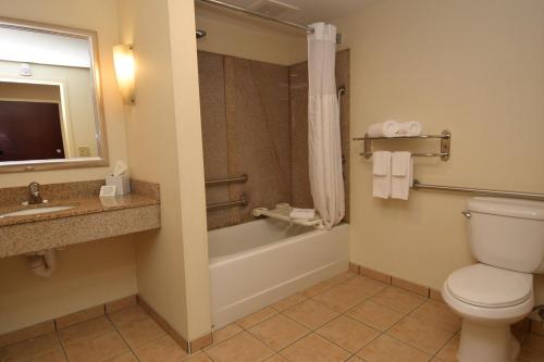 a bathroom with a toilet and a tub and a sink at Cicero Grand - Syracuse North in Cicero