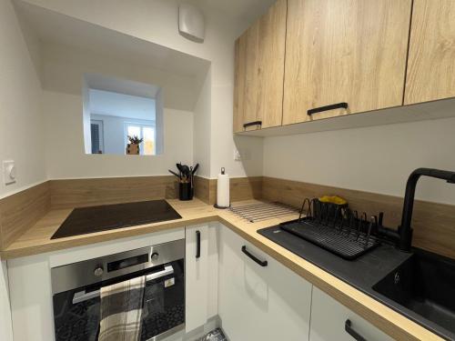 une cuisine avec des armoires blanches et un four à plaques de cuisson dans l'établissement Glacière Cozy, à Clermont-Ferrand