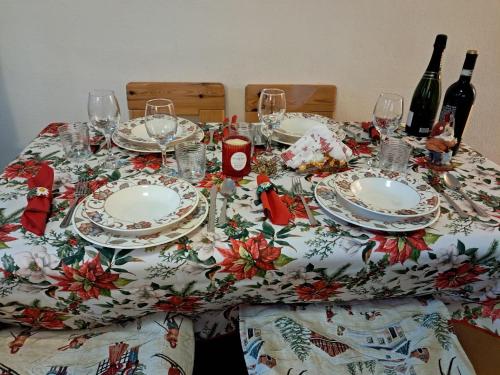 a table with plates and wine glasses on it at Appartamento rinnovato centralissimo a Cervinia in Breuil-Cervinia