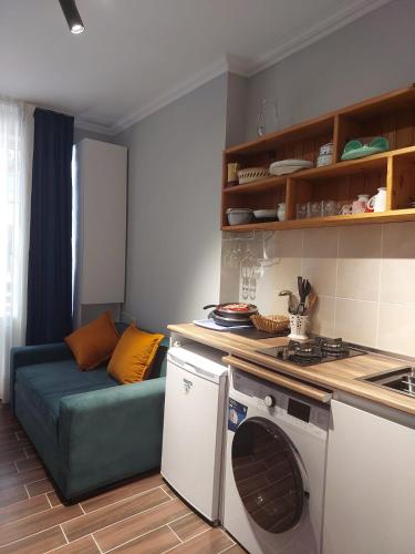 a kitchen with a couch and a washing machine at Sunny Valley apartment in Bakuriani
