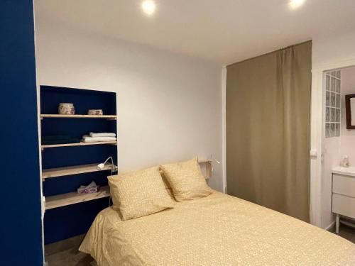 une chambre avec un lit et un mur bleu dans l'établissement Charmant et tranquille plein centre de Paris!, à Paris