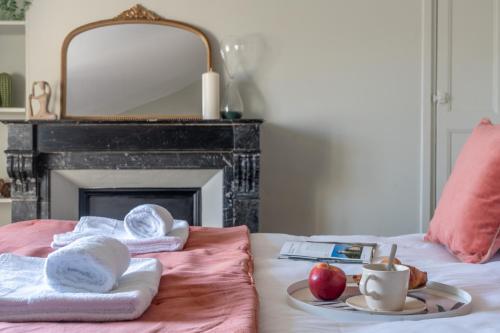- un lit avec des serviettes, une pomme et une tasse de café dans l'établissement Le Passage du Roi - Hypercentre, à Tours