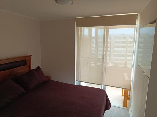 a bedroom with a bed and a large window at Los Molles apartment in Los Molles