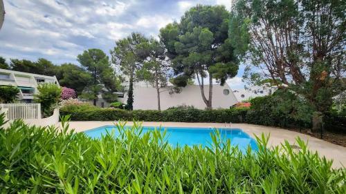 - une piscine dans une cour ornée de plantes dans l'établissement Ponant La Grande Motte Cosy Studio 4 pers Parking,Clim,piscine, Golf, Plage, à La Grande Motte