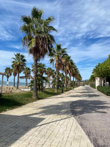 una strada con palme sul lato di una spiaggia di Joanon's landscape view a Golem