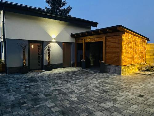 a house with a brick patio in front of it at Vila LEMAR wellness & spa in Huncovce