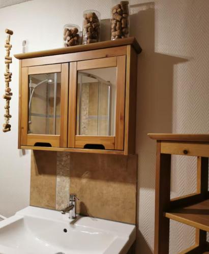 La salle de bains est pourvue d'un lavabo et d'une armoire en bois. dans l'établissement Les 3 Ceps, à Bergholtz