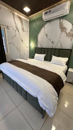 a bedroom with a large bed with a map on the wall at Hotel Maheshwari & Banquet Hall in Tehri-Garhwāl