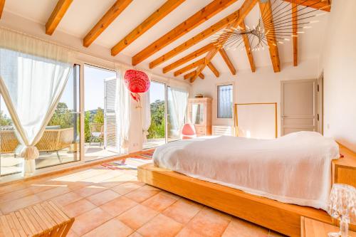 una camera da letto con un letto grande e grandi finestre di Villa La Ronde des Soleils a Coti-Chiavari