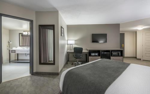 a hotel room with a bed and a desk and a television at Chateau Bedford Trademark Collection by Wyndham in Halifax