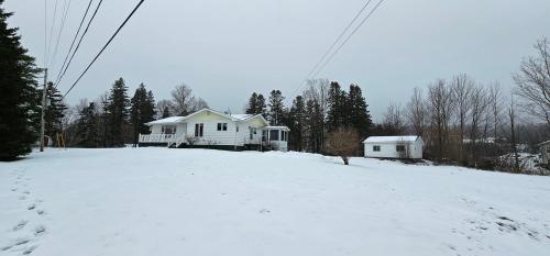 a house on top of a snow covered hill at Fair Isle Motel & The Nest in Whycocomagh