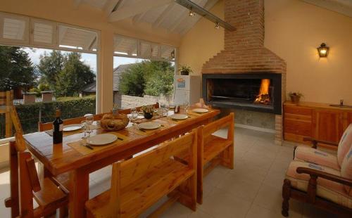 Un comedor con mesa y chimenea. en Apart Tronador Con Servicios!! Estacionamiento privado, en San Carlos de Bariloche