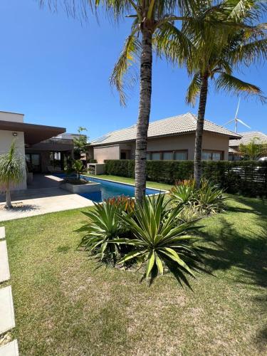a house with palm trees and a swimming pool at Villa Formentera - Casa 08 by The Coral Beach Resort in Trairi
