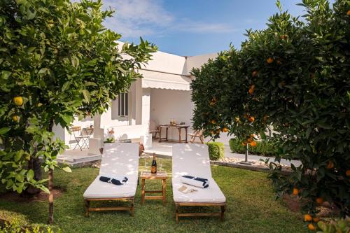 a garden with two chairs and an orange tree at Relaxing House with Garden in Nea Makri