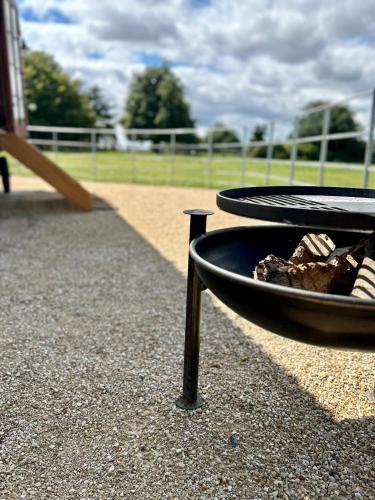 a fire pit in a park with a playground at The Hut at Blackberry Barn in Long Itchington