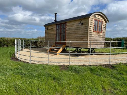 a small wooden house on a fence in a field at The Hut at Blackberry Barn in Long Itchington