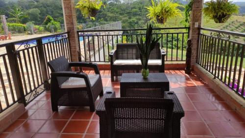 a balcony with chairs and a table with a plant at Casa Campestre Las Julianas in Socorro