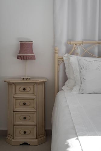 a lamp on a night stand next to a bed at Relaxing House with Garden in Nea Makri