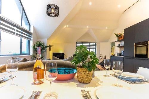 a table with wine glasses and a plant on it at The Loft - Bracklesham Bay in Chichester