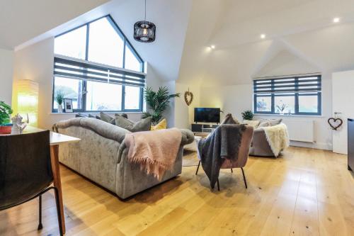 a living room with two couches and a table at The Loft - Bracklesham Bay in Chichester