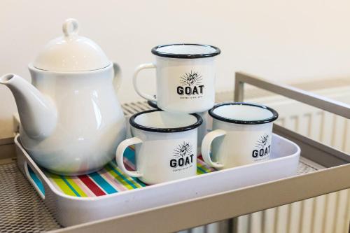 a tray with four coffee mugs and a tea pot at The Loft - Bracklesham Bay in Chichester